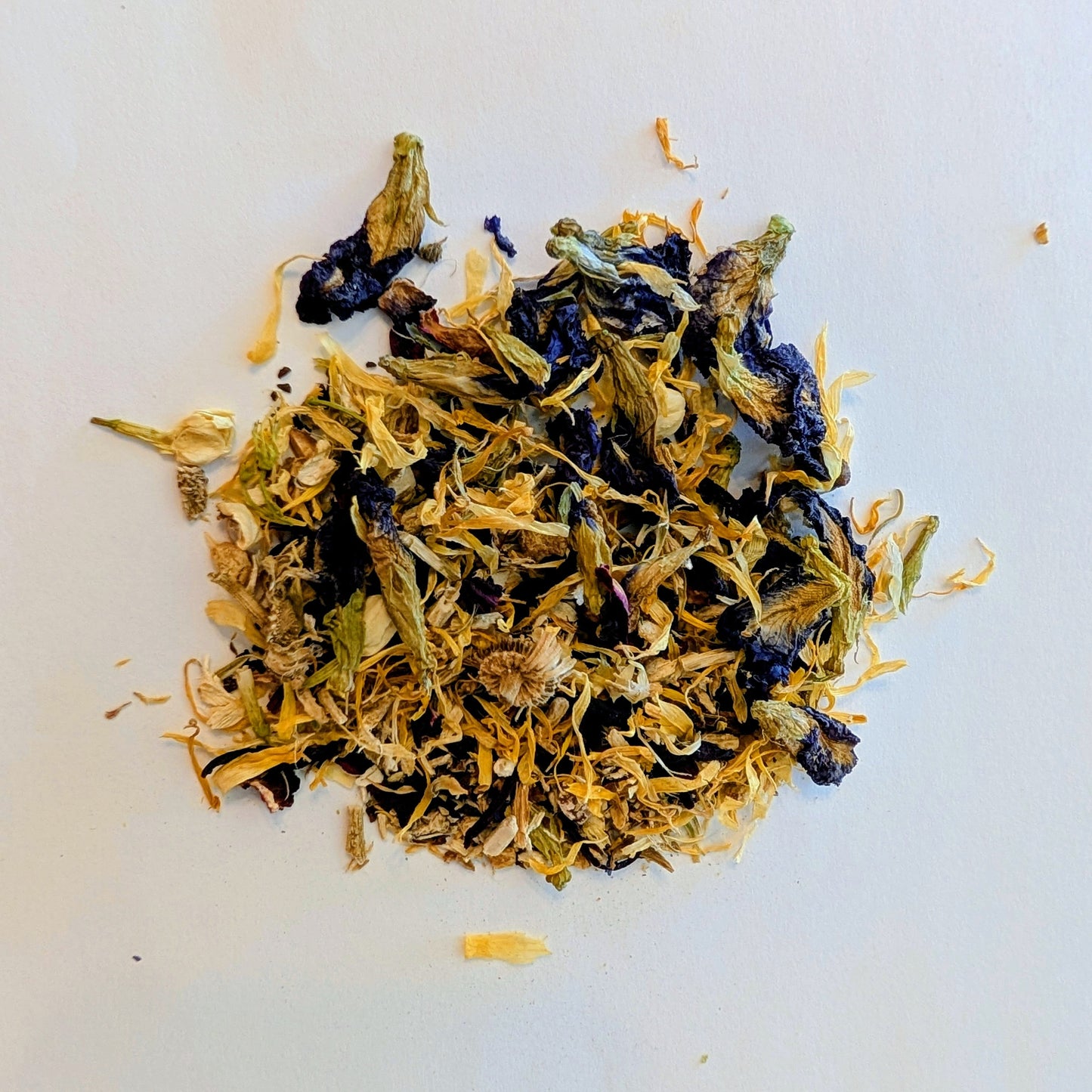Dried yellow and blue flower petals on a white background