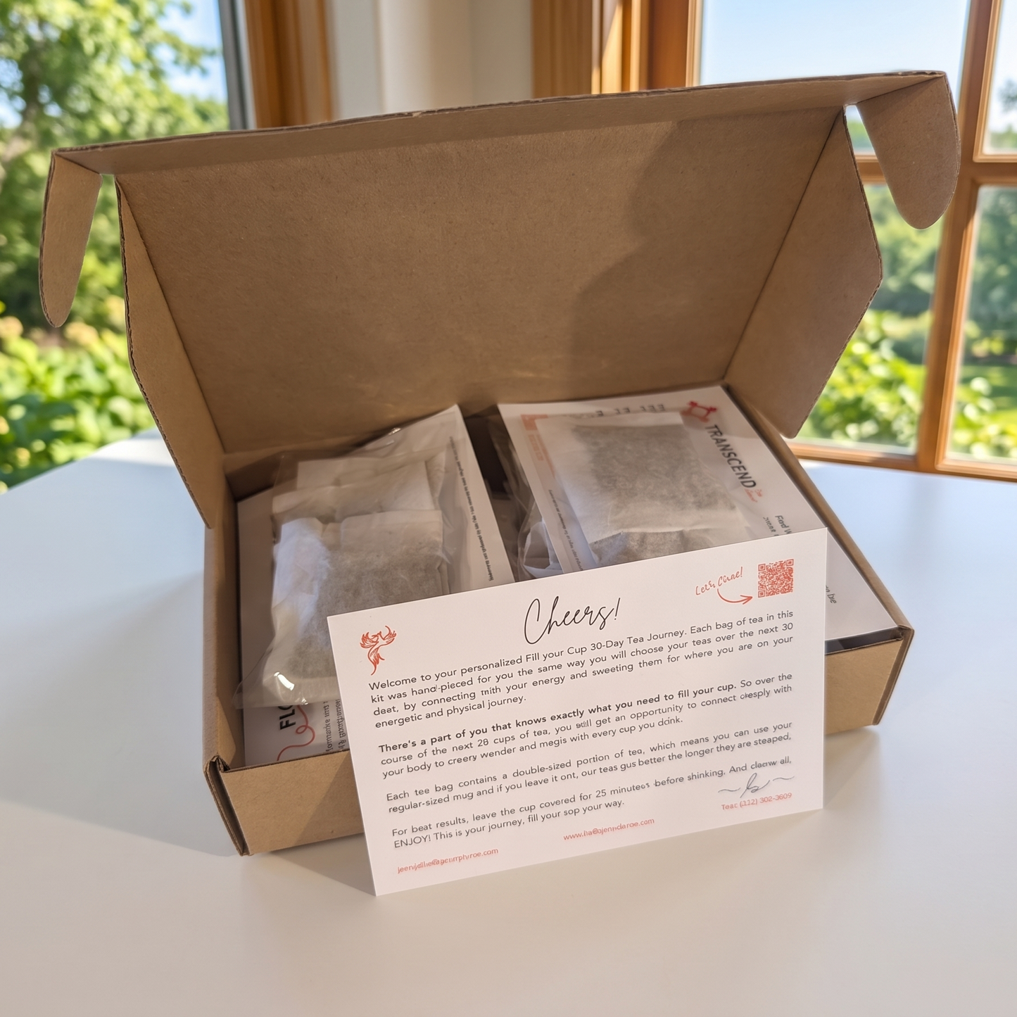 Box of tea bags with a card on a table with a window view