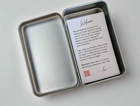 Metal tin with a welcome card inside on a white background